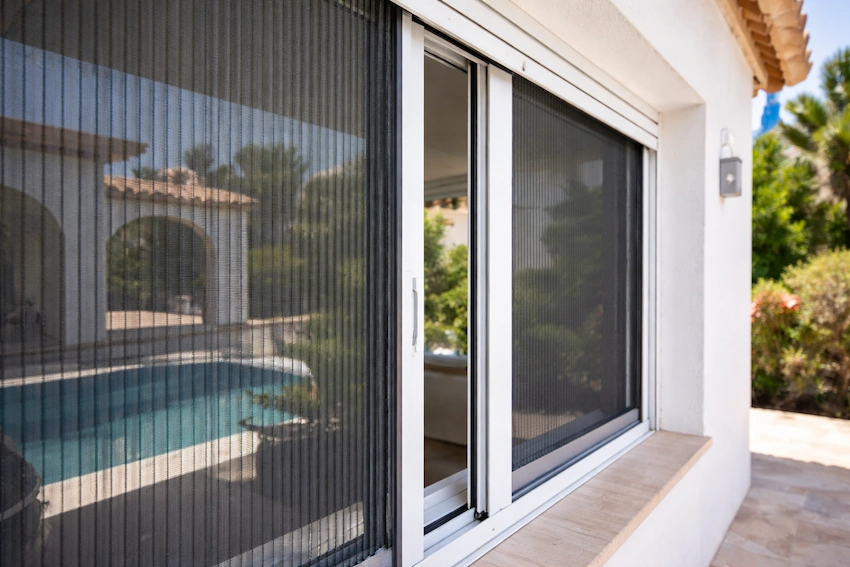 Mosquiteras plisadas en ventanas de villa